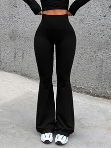 Detail view of black high waisted flared yoga pants on a model with premium stretch fabric