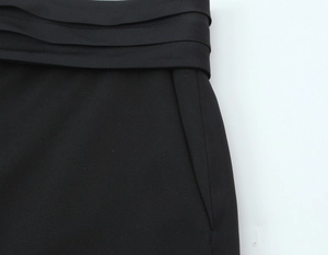 Détail de la veste cintrée noire avec taille plissée et finitions soignées en tissu