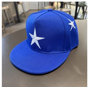 Détail macro de la broderie étoile blanche sur une casquette hip-hop bleue à bord plat