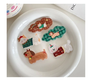 Detail of five acrylic Christmas hair clips with cartoon animal designs in a ceramic dish