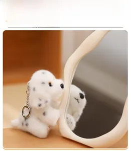 Close-up of a cute Dalmatian plush keychain with white faux fur and black spots