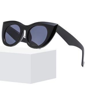Moderne schwarze Cat-Eye-Sonnenbrille mit breitem Rahmen auf weißem Podest