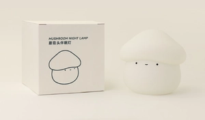 Detailed view of the mushroom night lamp next to its minimalist product packaging box