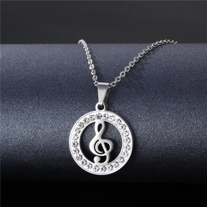 Macro detail of silver musical note necklace with sparkling pavé diamonds on grey background