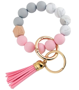 Detail of pink and grey silicone bead keychain bracelet with wooden bead and leather tassel