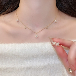 Close-up of elegant gold flower jewelry set with pearls and small diamonds on model