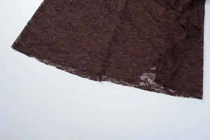 Detail of dark brown lace fabric with intricate floral patterns and breathable texture