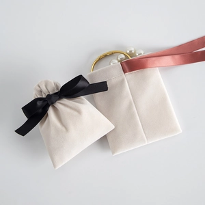 Detailed texture of off-white velvet jewelry pouch with soft ribbon drawstring closure