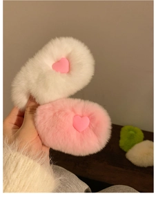 Close-up of soft plush hair clips in pink and white with heart patterns for women