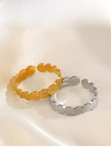 Detailed view of gold and silver hammered stainless steel rings on silk background