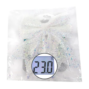Close-up of white sequined Christmas bow ornament weighing 23.0g on a digital scale