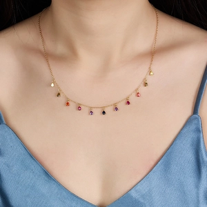 Close-up of rainbow teardrop necklace with colorful zircon gemstones on model's neck
