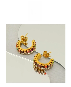 Vue macro des boucles d'oreilles créoles dorées 18k avec zircons colorés et reflet miroir