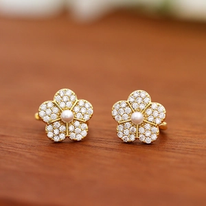Macro shot of gold floral earrings featuring white pearls and micro-pave zircons
