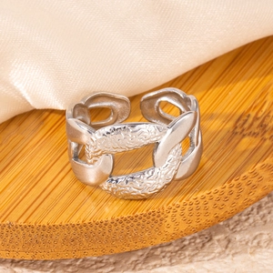 Macro detail of silver vintage chain ring with hammer texture on a bamboo base