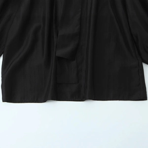 Elegant black long sleeve blouse in smooth satin fabric with delicate draping texture