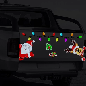 Detail showing festive Santa Claus and reindeer magnetic stickers on a black truck tailgate