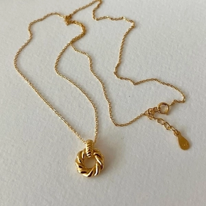 Detailed macro view of S925 hallmark on a gold-plated sterling silver twisted ring necklace