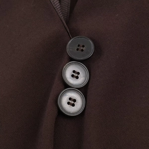 Close-up of three dark buttons on chocolate brown twill fabric with detailed texture