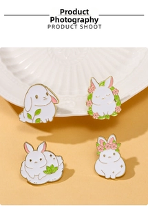 Macro detail of four cute white rabbit enamel pins with gold trim and pastel colors