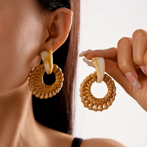 Detail showing bohemian round woven rattan earrings with marbled resin and bamboo texture