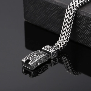 Macro shot of Viking Eye charm on silver titanium steel wheat chain bracelet for men