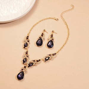 Luxury gold-tone jewelry set with purple teardrop stones and sparkling crystals