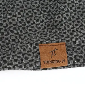 Black and gray checkerboard knit beanie hat with brown faux leather brand patch