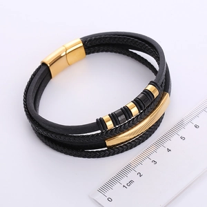 Detail view of multi-layer braided leather bracelet with golden magnetic clasp and ruler