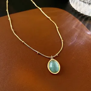 Elegant gold titanium steel necklace with an oval green cat-eye stone pendant on leather