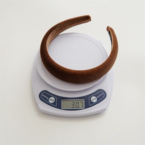 Close-up showing the 30.7g lightweight design of a padded velvet headband on a scale