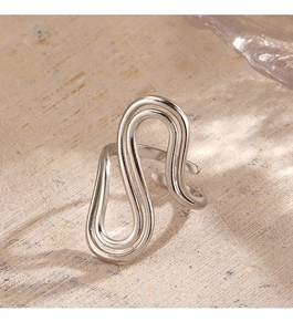 Macro shot of silver abstract wavy double-layer stainless steel ring on textured stone
