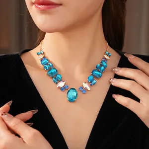 Luxury gold necklace with mixed blue and iridescent crystals on a model