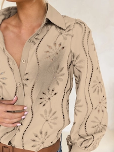 Detail of apricot puff sleeves and intricate floral eyelet embroidery on casual shirt