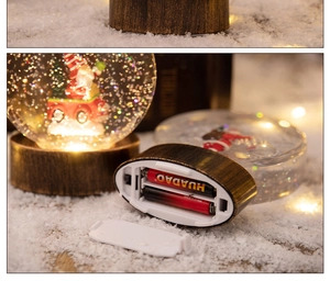 Gros plan du socle de la boule de Noël montrant le compartiment pour les piles LED