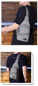 Detail of gray canvas men's chest bag with multiple zipper pockets and adjustable strap