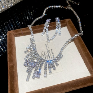 Macro shot of silver zircon jewelry set featuring fringe necklace and drop earrings