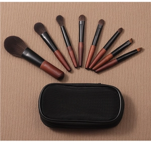 Detailed set of 8 mini portable makeup brushes with soft bristles and a black mesh pouch