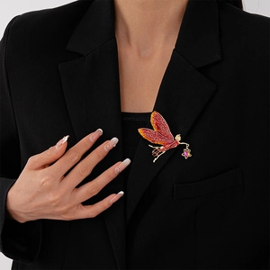 Detail of a vintage fairy brooch with purple star crystal worn on a black suit blazer