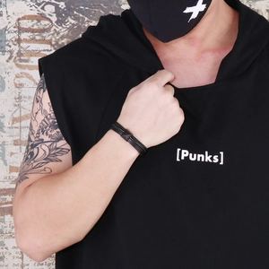Détail d'un bracelet multicouche en cuir tressé noir avec fermoir punk en acier