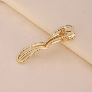 Detail showing wavy double-layer golden metal hair clip with polished finish surface