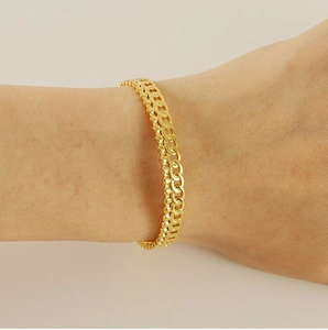 Détail du bracelet tressé plaqué or 18 carats montrant la chaîne à double couche au poignet