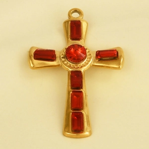 Close-up of gold stainless steel cross pendant with red gemstones and circular texture