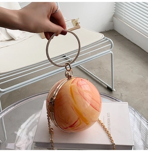 Macro detail of the spherical bag showing marble texture and diamond-encrusted metal handle