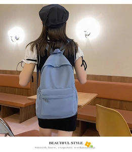 Lifestyle shot of light blue casual backpack with front pocket in a cozy cafe setting
