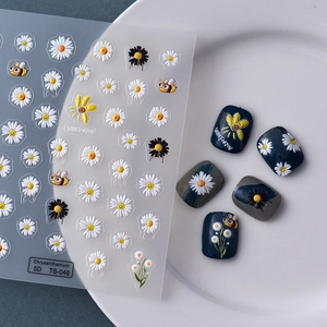 Détail macro de stickers 5D en relief marguerites et abeilles pour nail art sur ongles