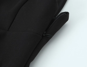 Detailopname van onzichtbare rits op zwart geweven jurk voor damesmode