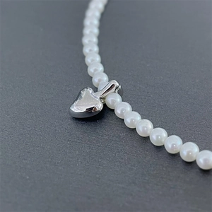 Minimalist white pearl necklace featuring a polished S925 sterling silver heart pendant