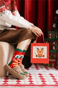 Cozy Christmas gift set featuring red cotton socks, plush slippers, and a festive reindeer bag