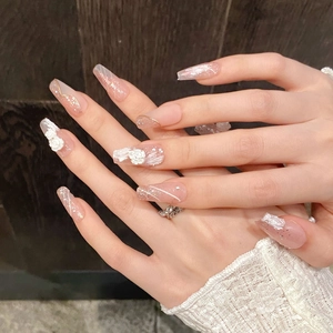 Pink press-on nails with 3D white roses and gold accents in elegant coffin shape